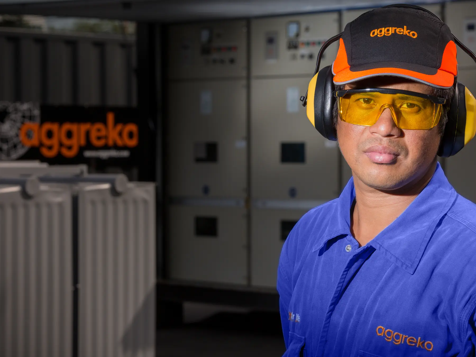 Colaborador da Aggreko com EPI completo em frente a equipamento elétrico industrial