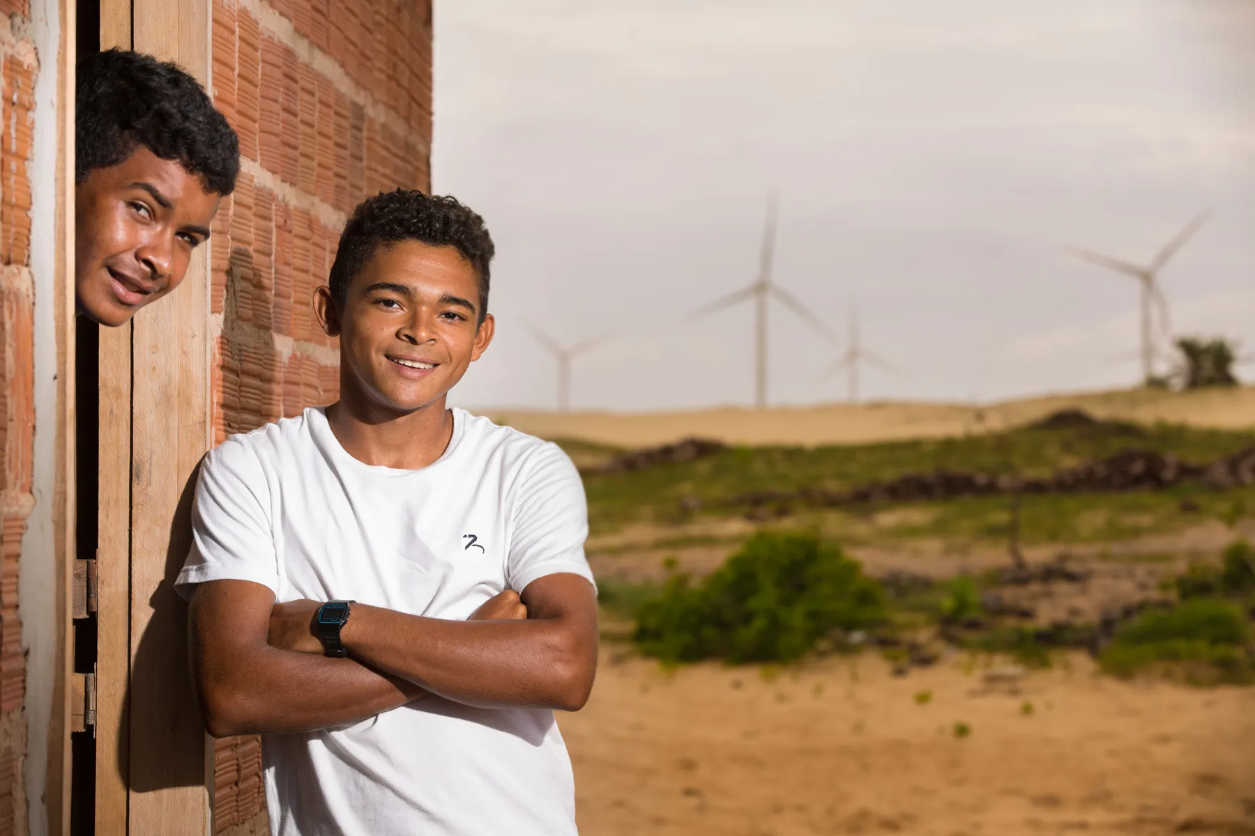 Moradores dentro do Complexo Eólico de Amontada, Ceará, com turbinas ao fundo em território costeiro