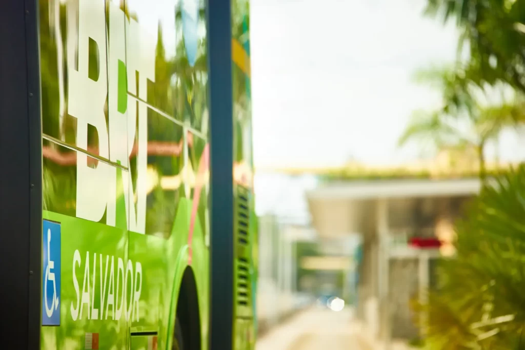 Ônibus do BRT Salvador com símbolo de acessibilidade em estação urbana com paisagismo tropical