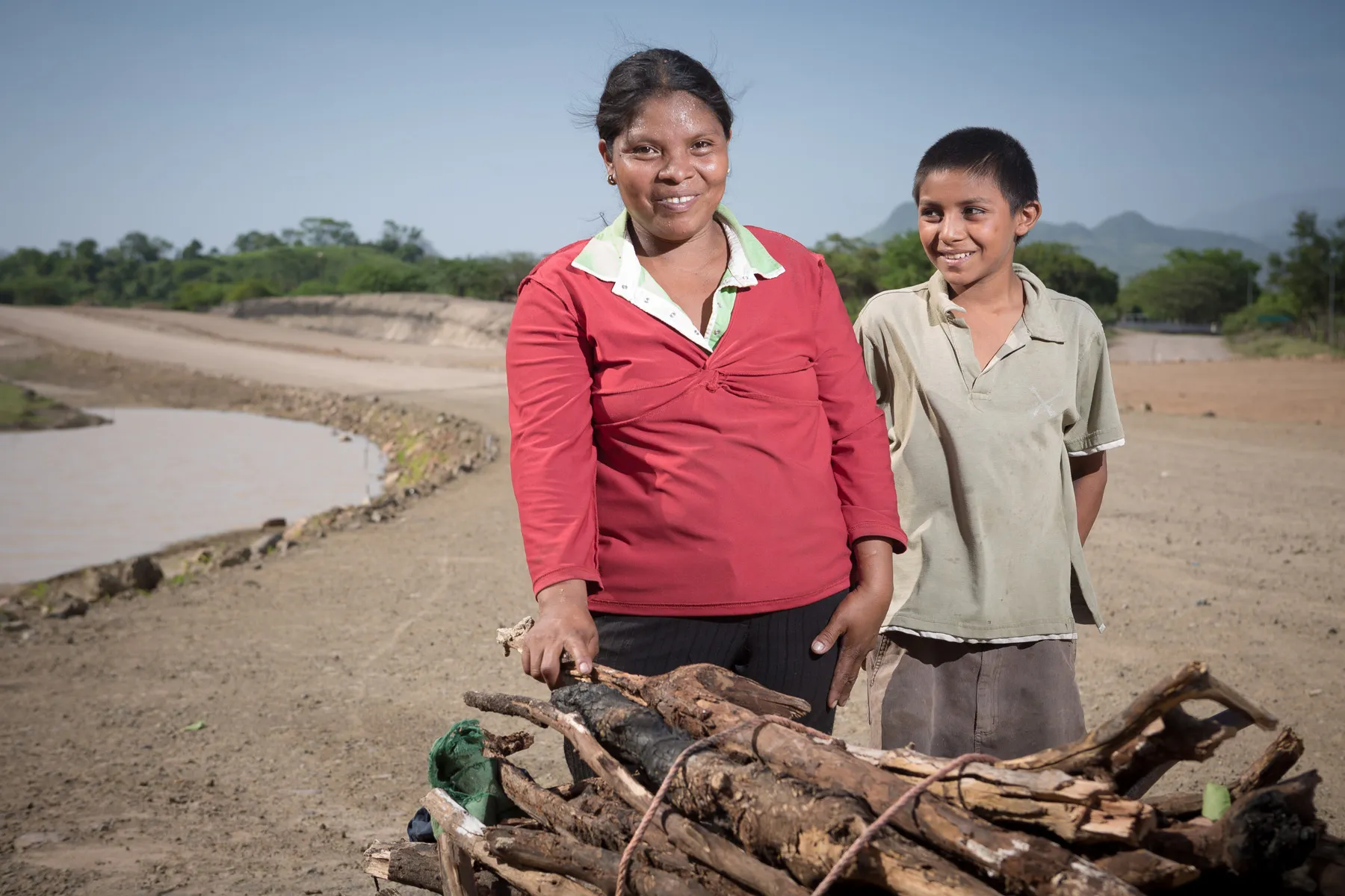 Moradores próximos ao canal entre Honduras e El Salvador, beneficiados por obras rodoviárias da Queiroz Galvão