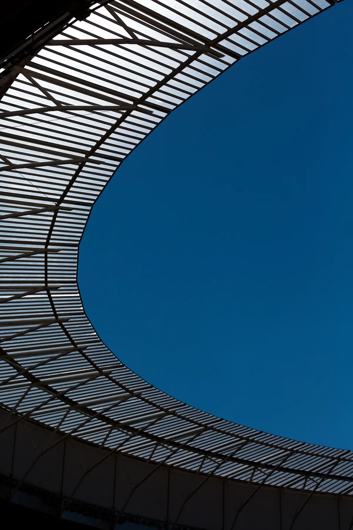 Estrutura da cobertura do Estádio Mané Garrincha em Brasília, vista interna com céu azul ao fundo