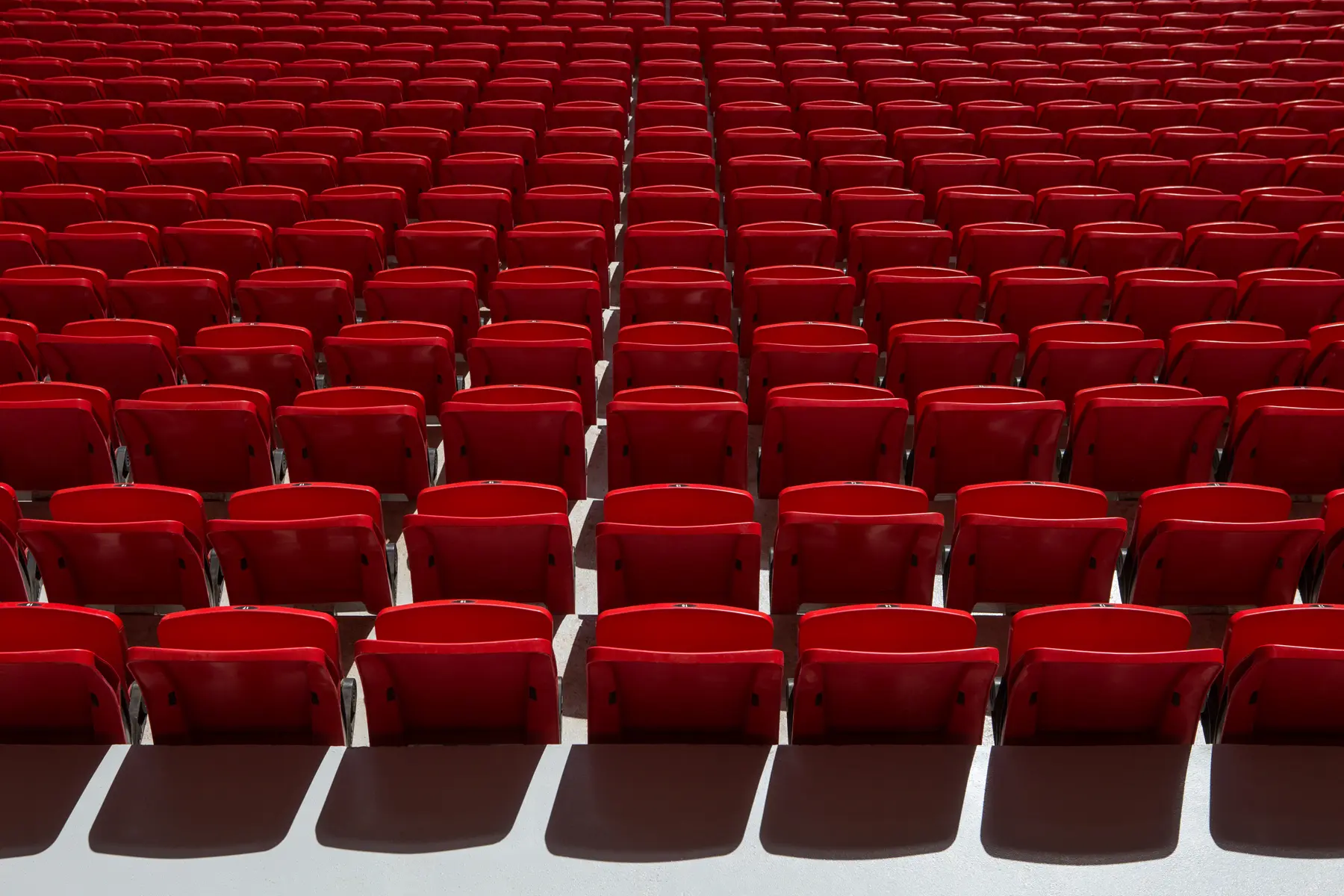 Cadeiras vermelhas organizadas em fileiras no Estádio Mané Garrincha em Brasília, padrão Copa do Mundo