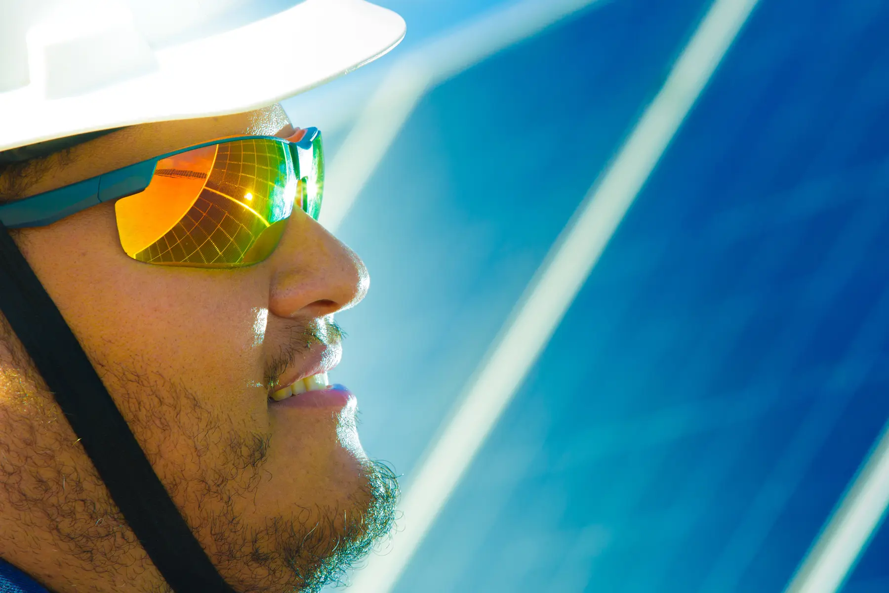 Colaborador em parque solar no Nordeste brasileiro com reflexo das placas solares nos óculos de segurança