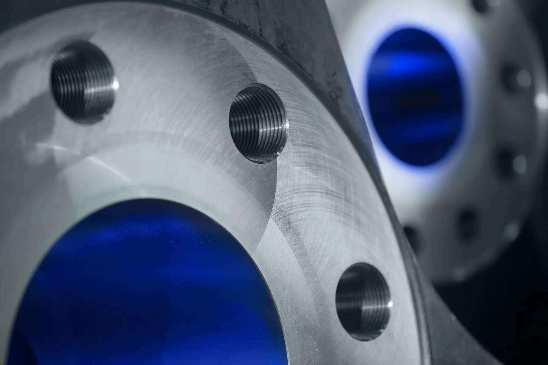 Detalhe de flanges metálicos usinados com acabamento de precisão em ambiente industrial