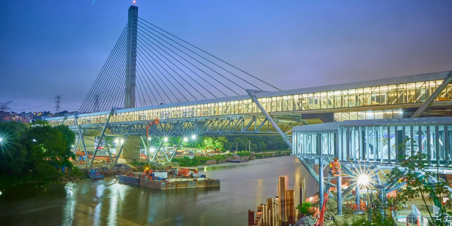 Estação Santo Amaro do metrô em São Paulo ao entardecer, com ponte estaiada e obras ao redor