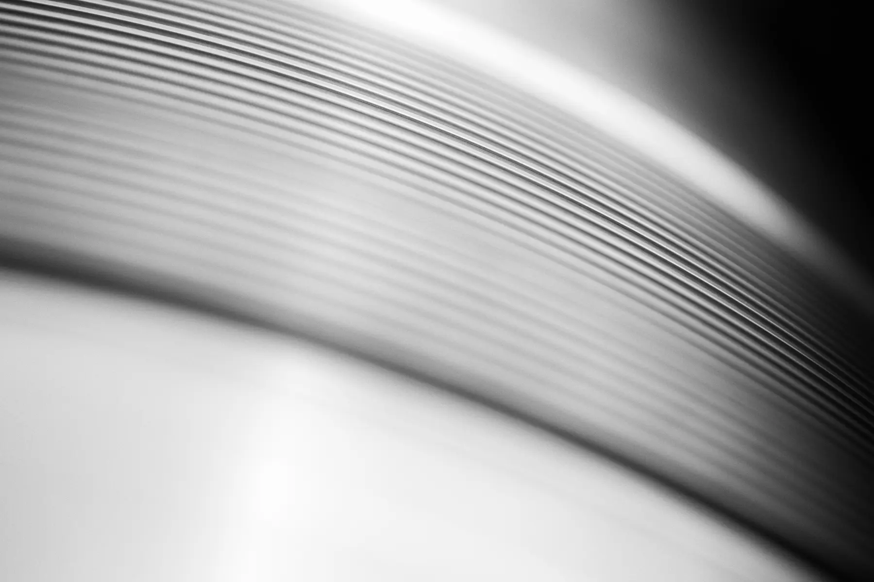 Detalhe em preto e branco de superfície usinada com padrão circular e acabamento técnico