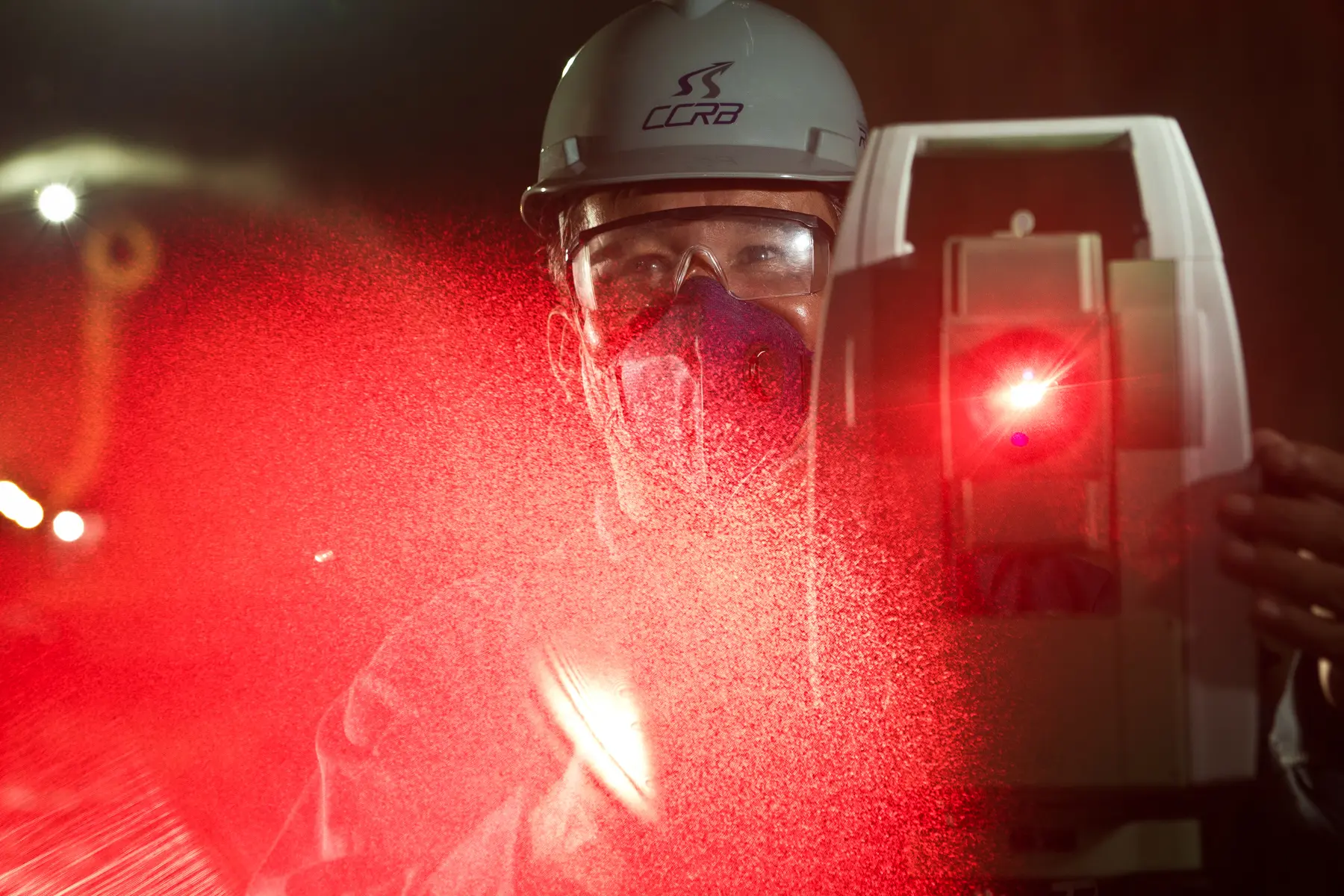 Topógrafo com EPI operando escaneamento a laser em túnel de obra do metrô no Rio de Janeiro