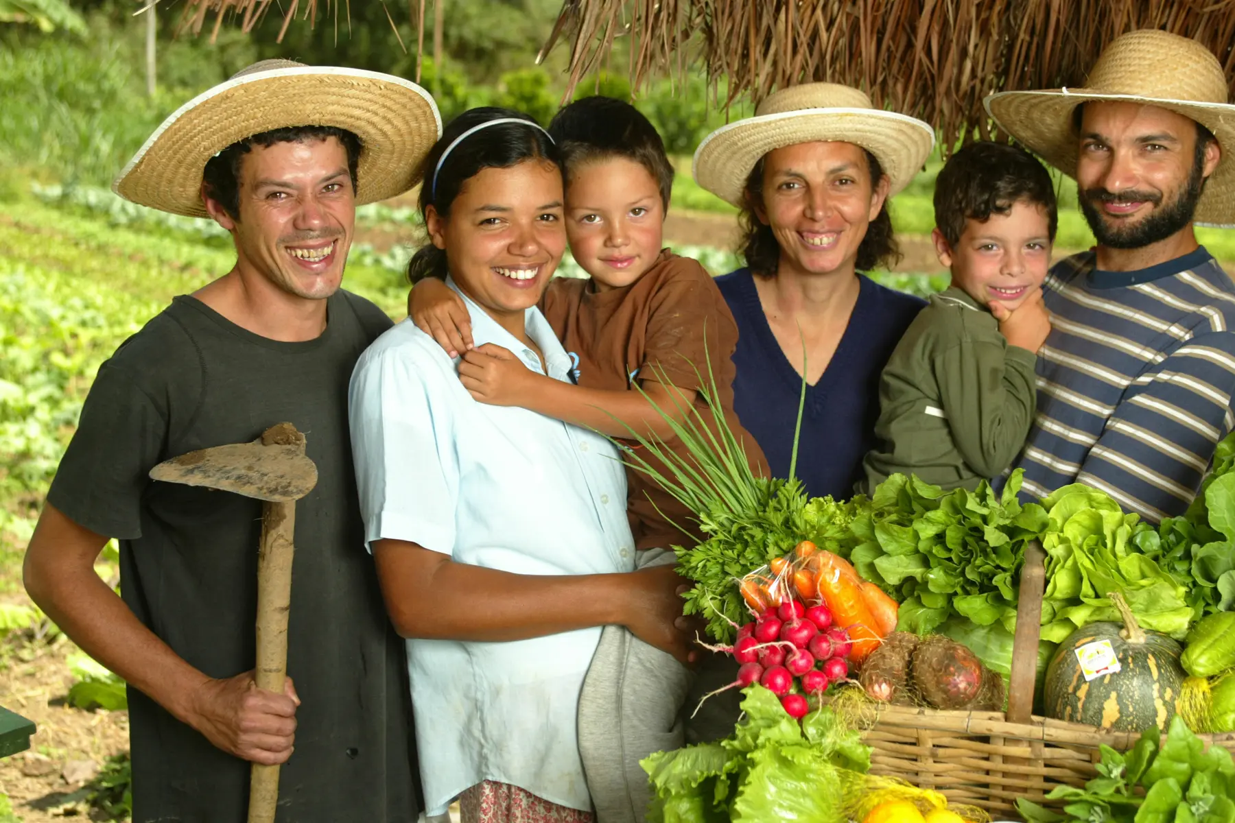 Pessoas em fazenda com cesta de vegetais variados