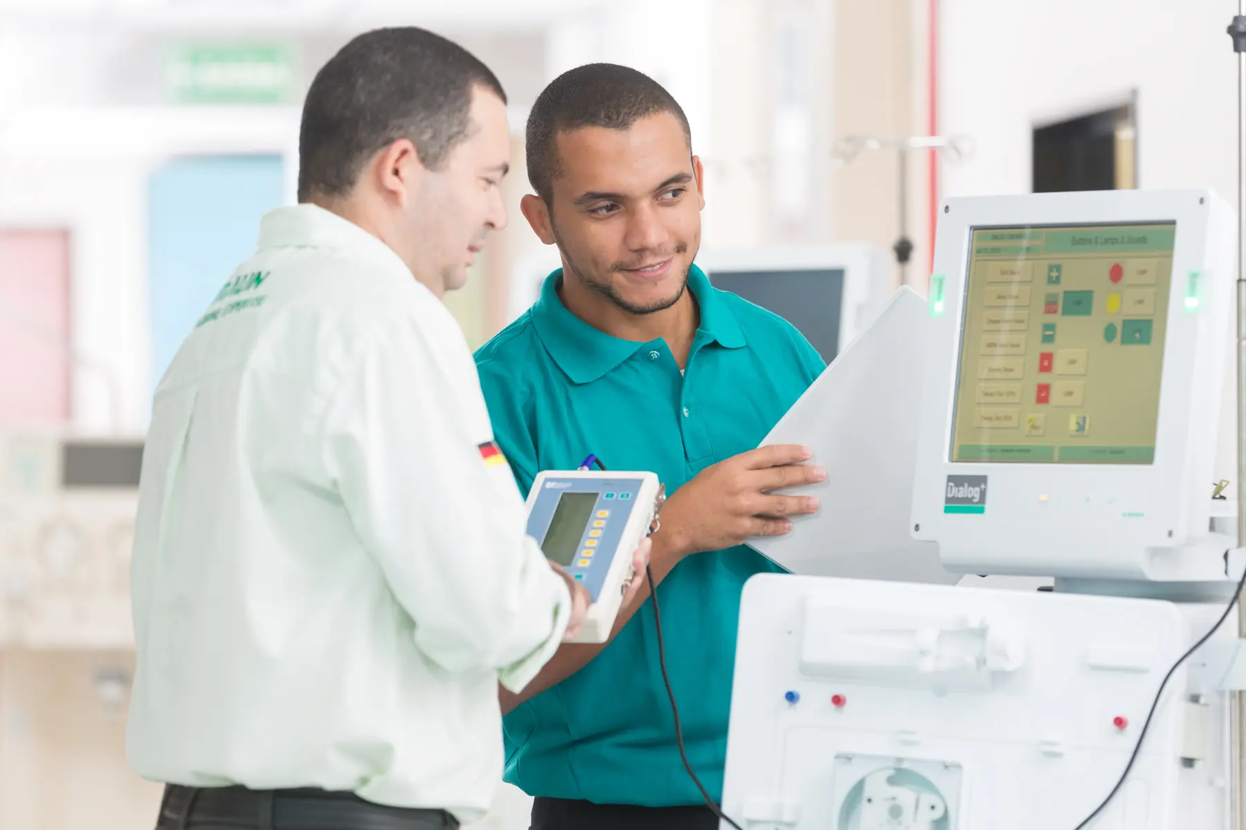 Profissionais em ambiente clínico operando máquina de hemodiálise Dialog+ da B. Braun com interface digital.