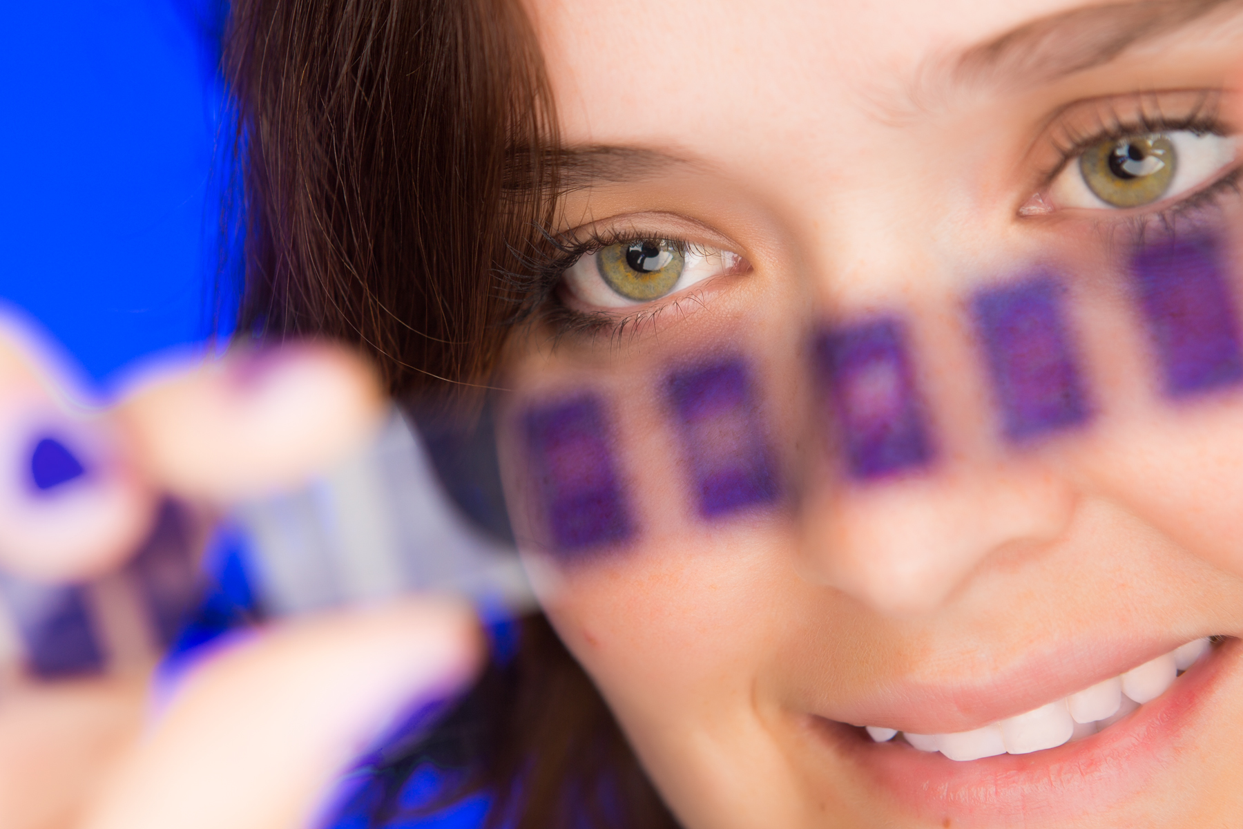 Pessoa segurando microarray com seções roxas em ambiente azul de laboratório,microfilmadora Kodak IMAGELINK.