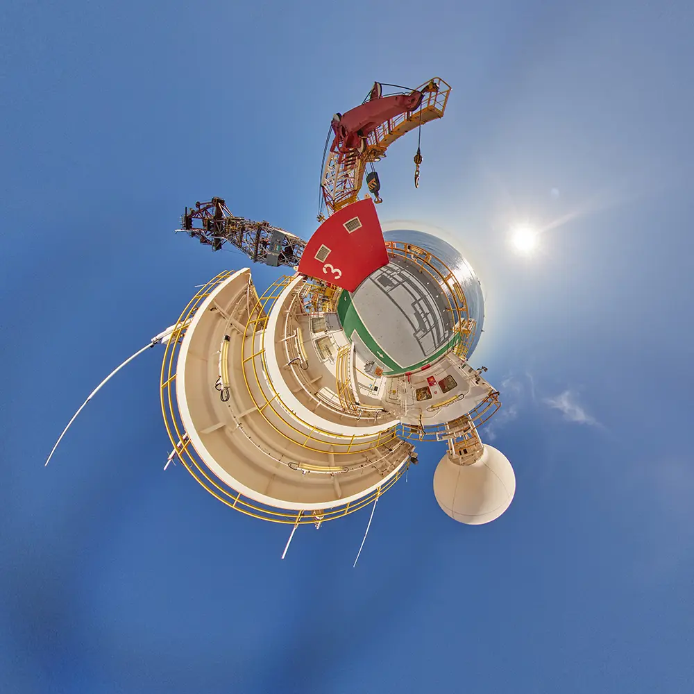 Imagem estereográfica de plataforma offshore com guindaste vermelho, heliponto e equipamentos industriais.