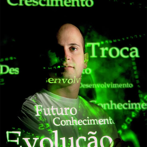 Retrato de André Vale com projeção digital de palavras como crescimento, conhecimento e evolução sobre fundo escuro.