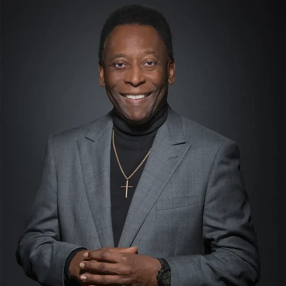 Retrato de Pelé, o Rei do Futebol, em pose formal com expressão serena e fundo escuro.