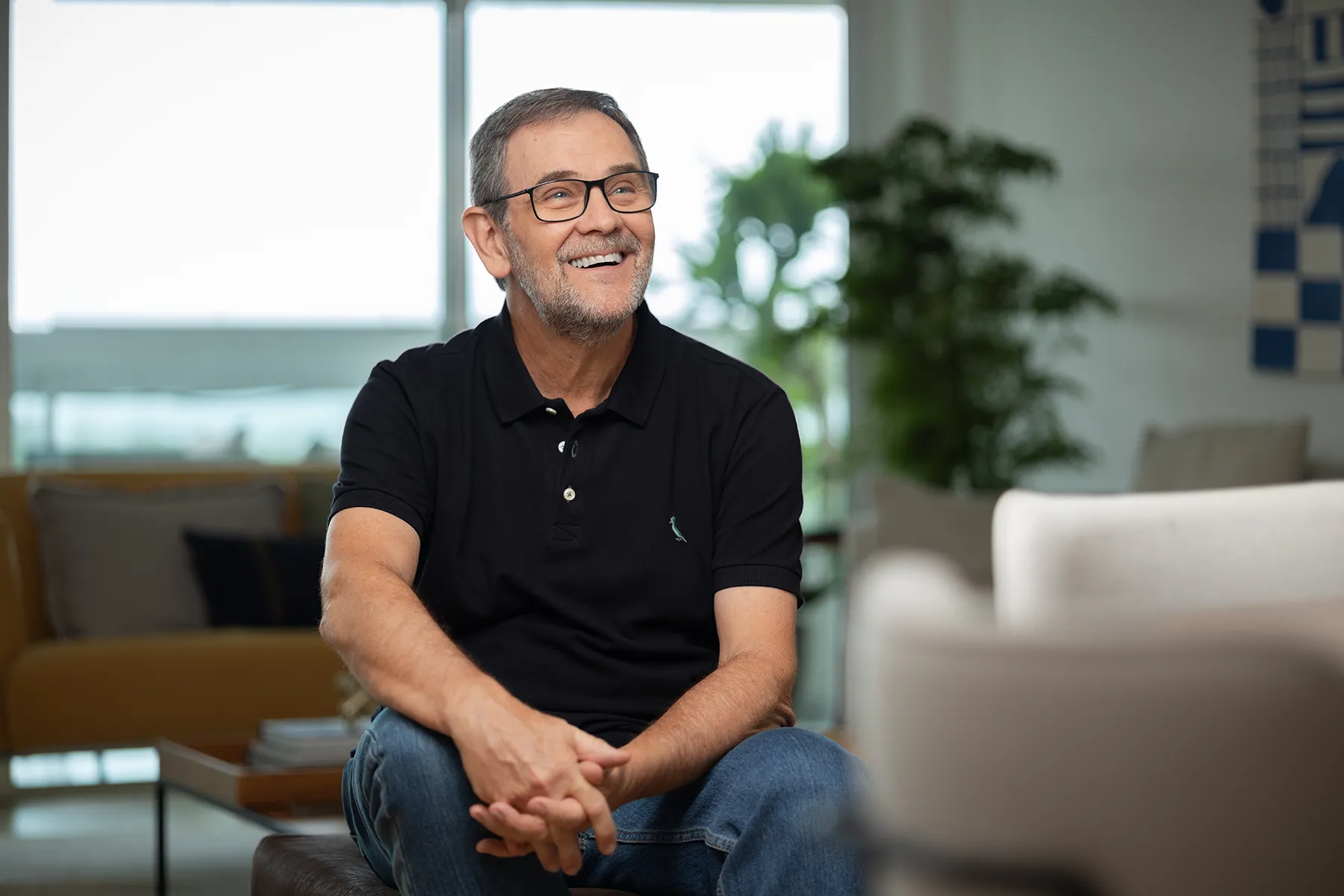 Executivo sorrindo durante entrevista corporativa em ambiente empresarial moderno.
